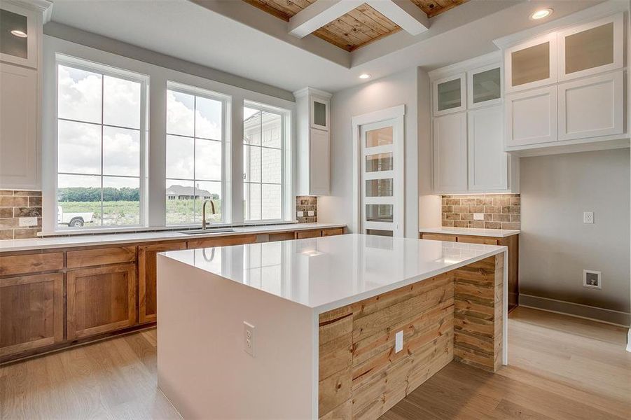 Kitchen with backsplash, a center island, and light hardwood / wood-style flooring