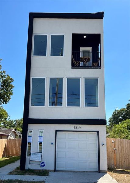 Contemporary house featuring a balcony and a garage