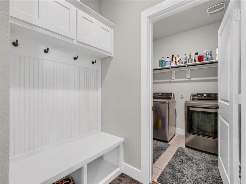 Mudroom featuring light wood-type flooring and washing machine and clothes dryer