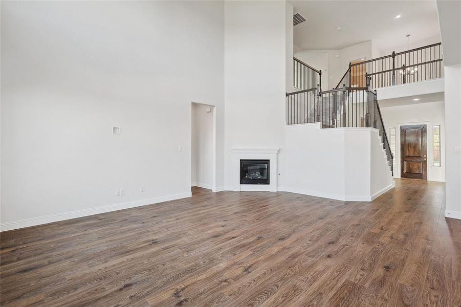 Unfurnished living room with a high ceiling and dark hardwood / wood-style flooring