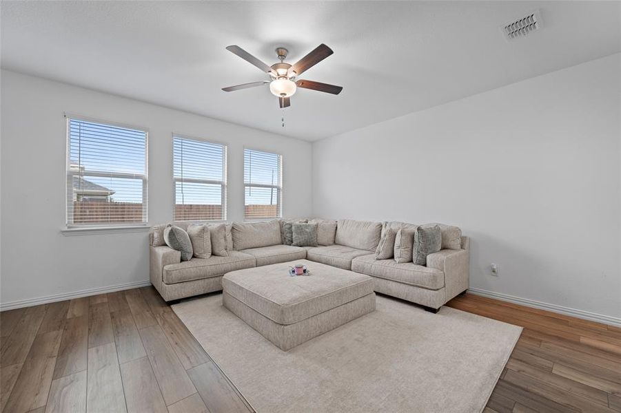 Living room featuring hardwood / wood-style flooring and ceiling fan