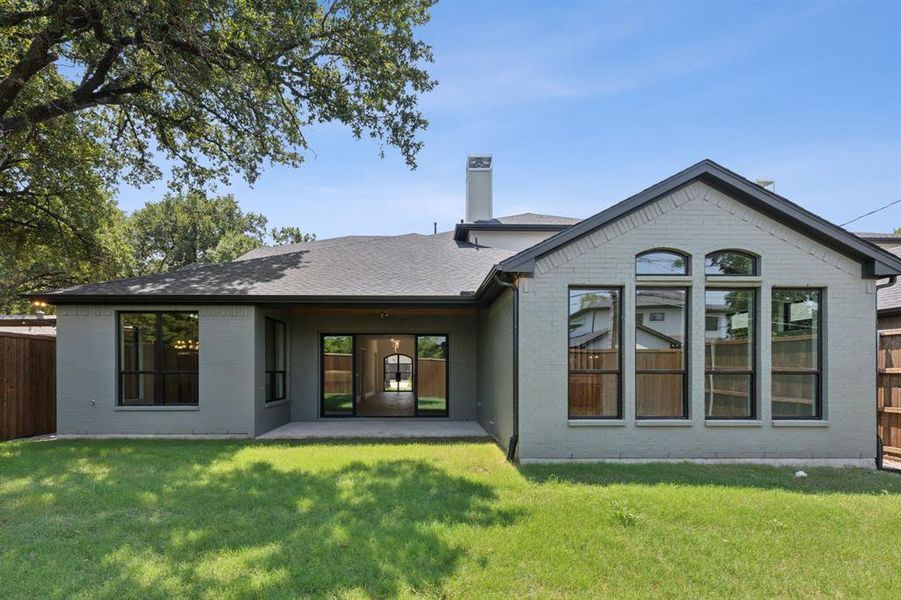 Rear view of property with a lawn