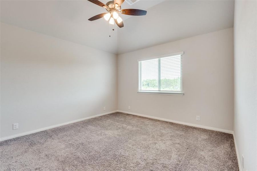 Carpeted spare room featuring ceiling fan