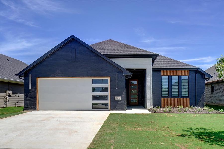 View of front of home with a garage and a front yard