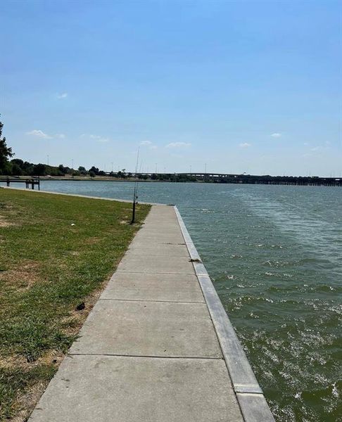 View of dock with a water view and a lawn