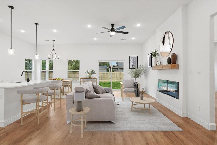 Living room featuring sink, ceiling fan with notable chandelier, and light hardwood / wood-style floors