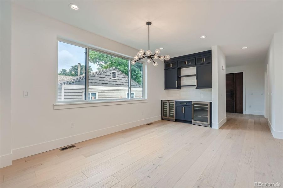 Bright, airy dining area has built-ins with wine and beverage fridges.