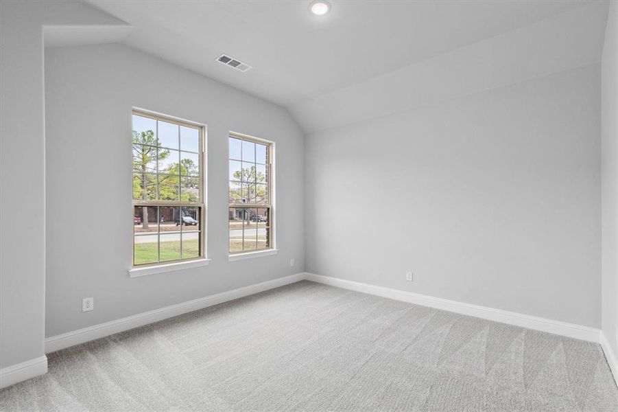 Carpeted empty room with vaulted ceiling