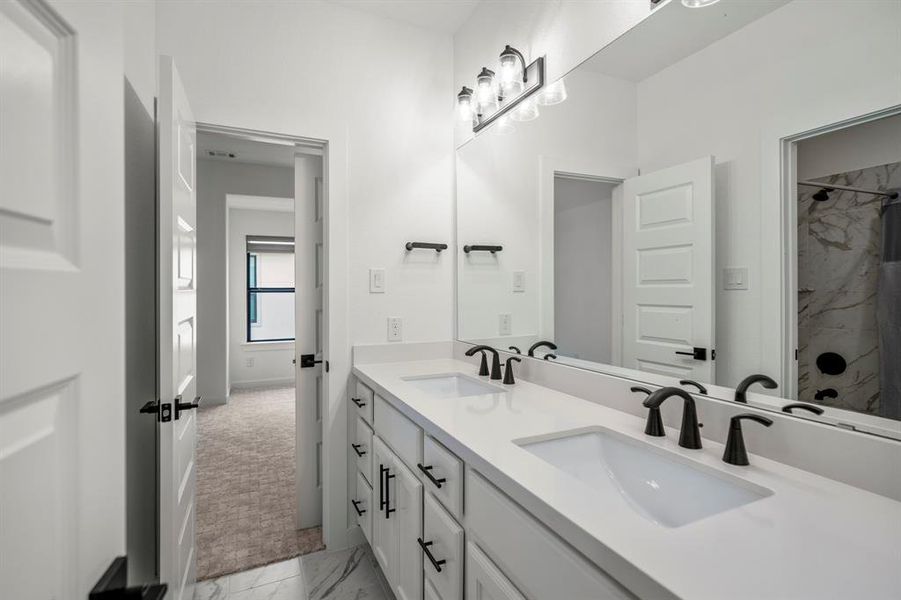 This full bathroom is located between the secondary bedrooms making it easy to share and get ready. It features a large vanity, white cabinets, quartz countertops, and a separate space for the large combination tub and shower.