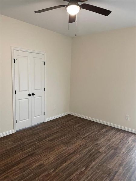Unfurnished room with dark hardwood / wood-style flooring and ceiling fan