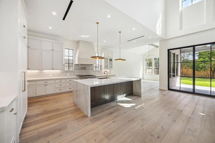 A chef’s dream kitchen featuring custom cabinetry, a large island with a marble countertop, and designer pendant lighting. High-end Thermador appliances complete the elegant and functional design.