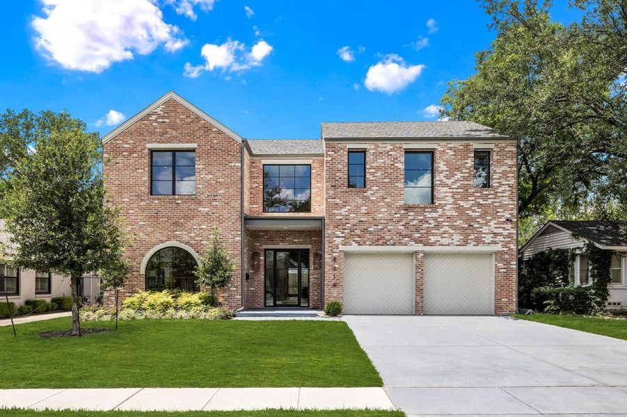 View of front of house featuring a garage and a front yard