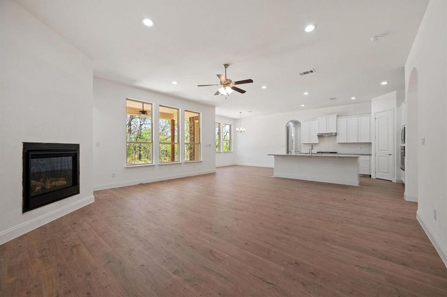 Unfurnished living room with wood-type flooring and ceiling fan