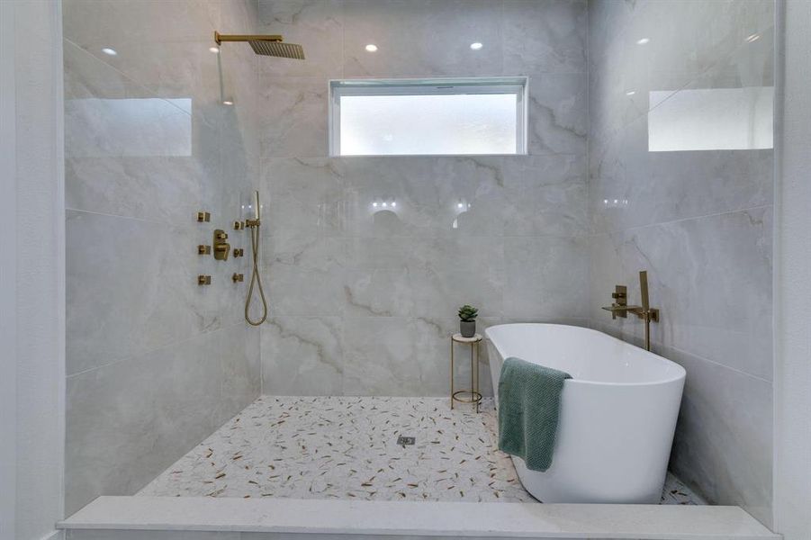 Bathroom with tiled shower and tile walls