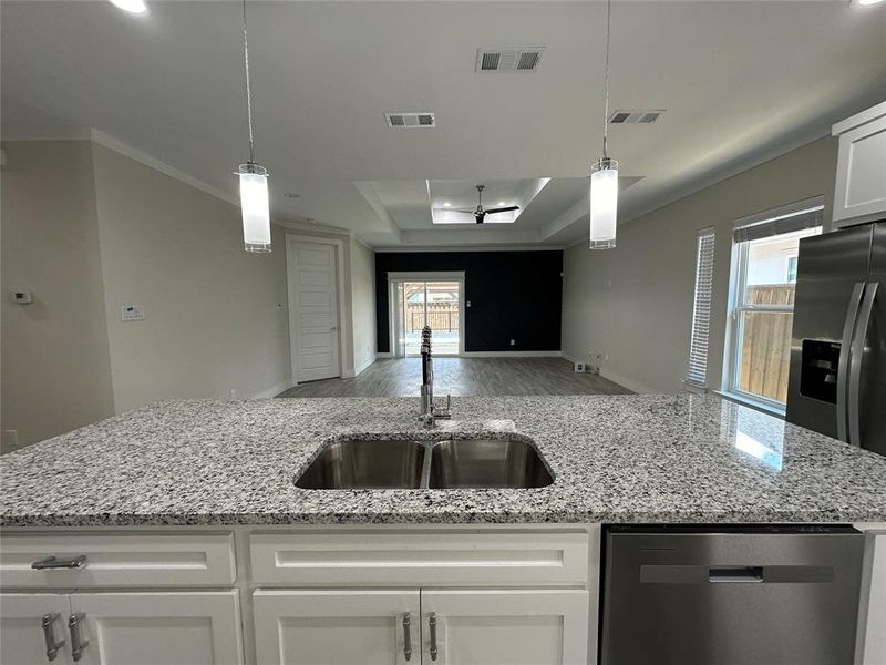 Kitchen featuring white real wood cabinets, light stone granite counters, premium dishwasher, double door refrigerator with ice maker and pendant lighting.  Pictures do not do justice.