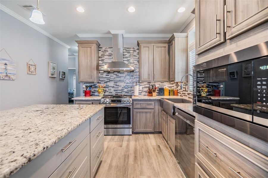 All the Bells and whistles in this Airy kitchen with pendant lights over center bar island