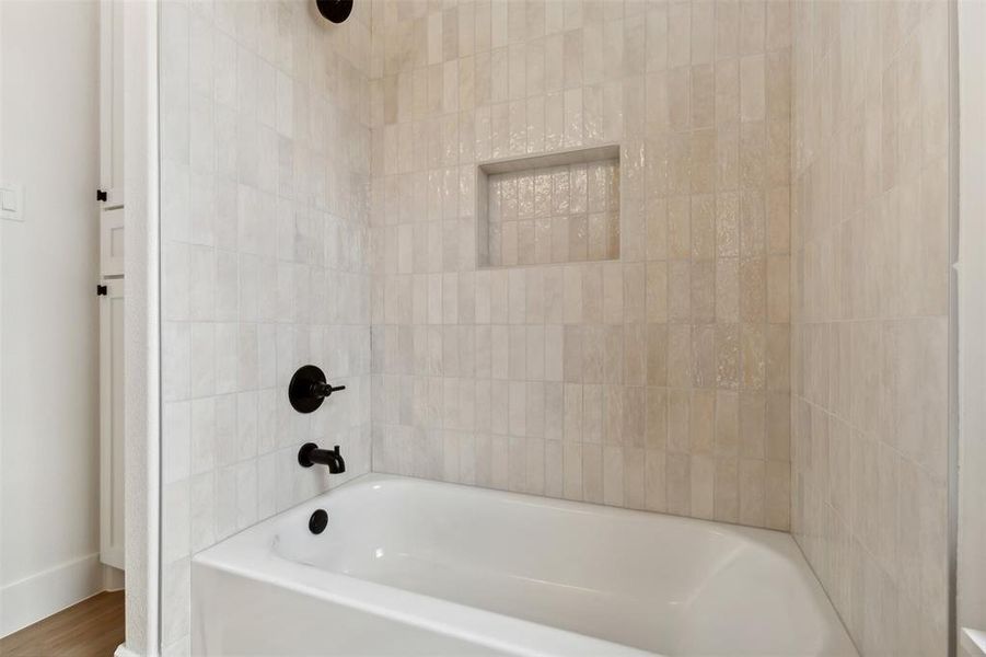 Bathroom with wood-type flooring and shower / tub combination