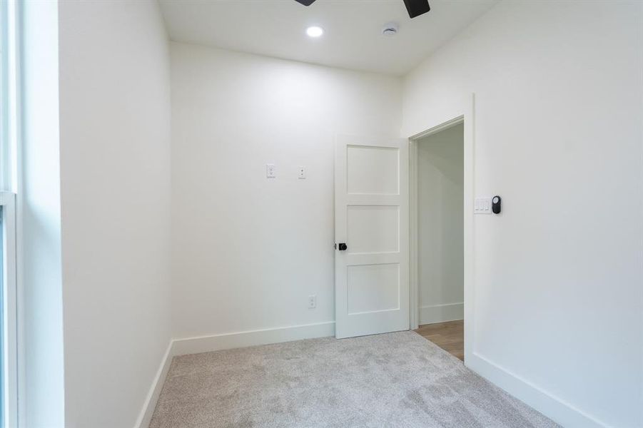 Carpeted empty room featuring ceiling fan