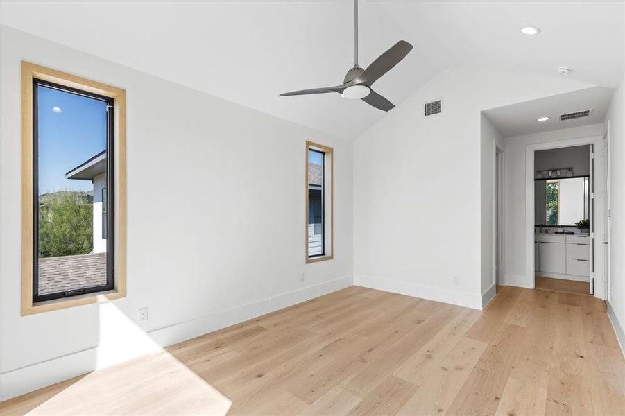 Empty room featuring light hardwood / wood-style floors, vaulted ceiling, and ceiling fan