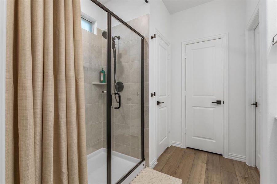 Bathroom featuring hardwood / wood-style flooring and shower