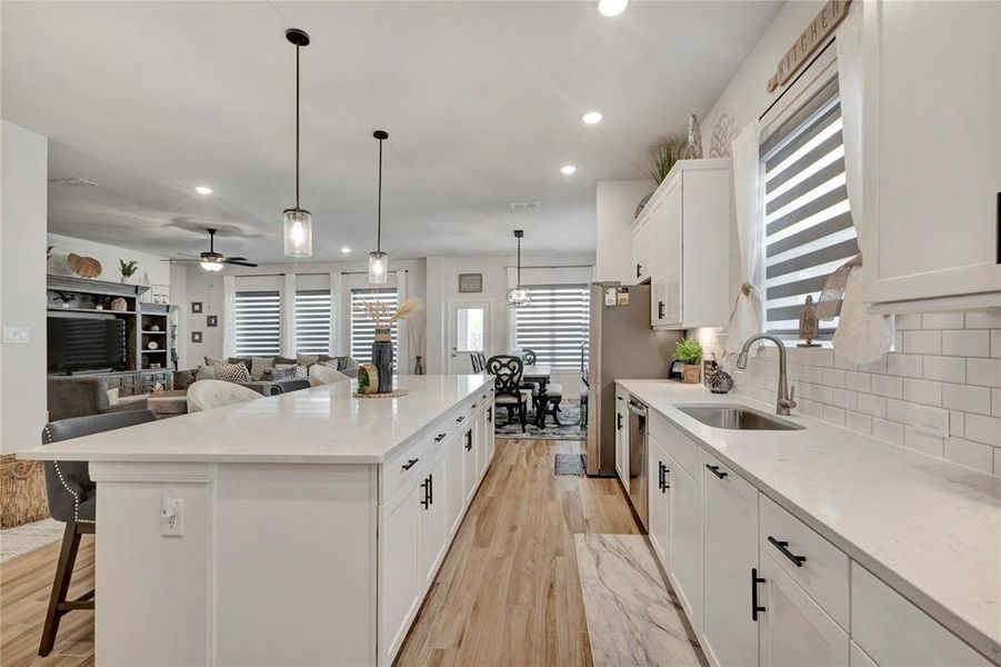 Modern Kitchen Design - Shows the dining room area, backdoor to custom outdoor living space, and a glimpse of the living room, highlighting the clean and fresh design with beautiful hardware and countertops.