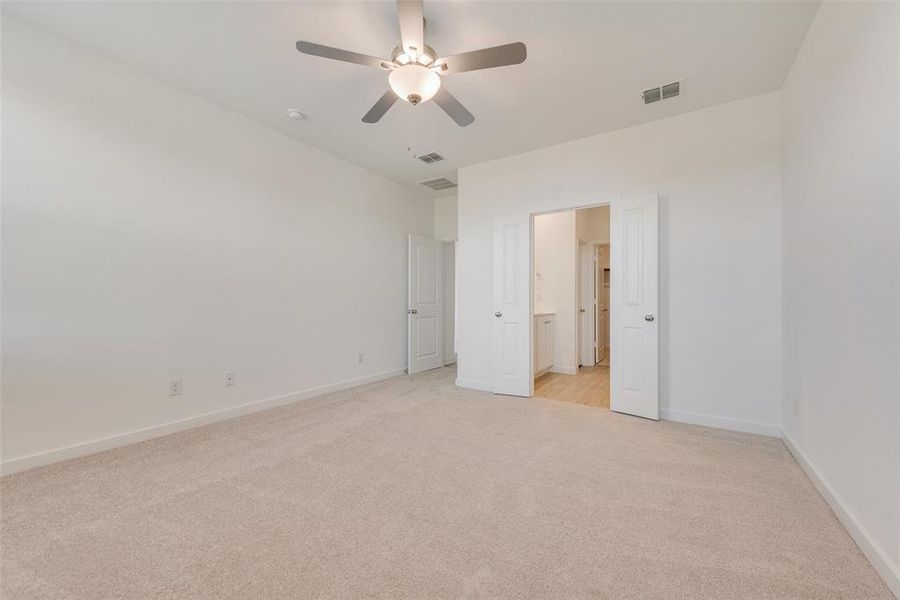 Unfurnished bedroom featuring light colored carpet and ceiling fan