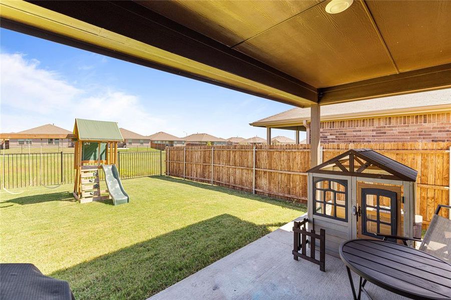 View of yard featuring a playground and a patio