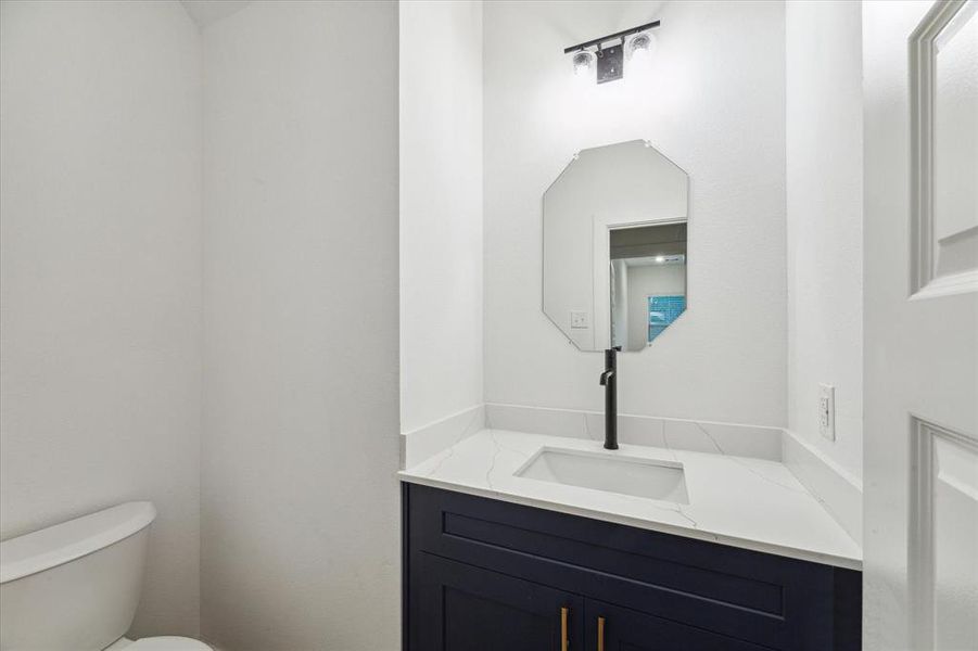 The chic powder room, conveniently located on the main level, features contemporary fixtures and a crisp, clean design.