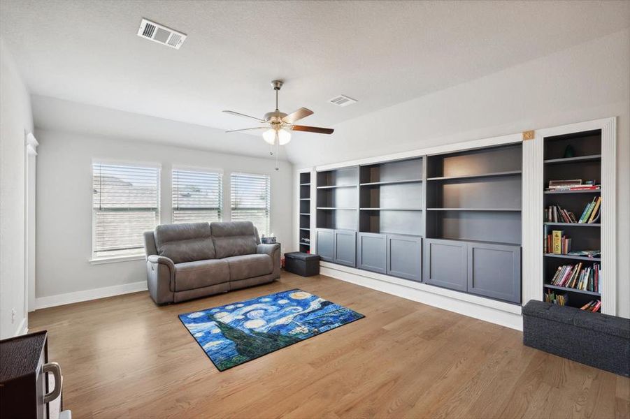 Living room with ceiling fan and hardwood / wood-style floors