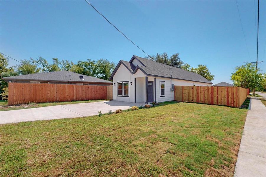 View of front of home with a front yard and a patio area