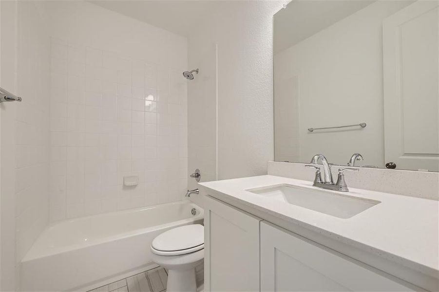 Full bathroom featuring tile floors, tiled shower / bath combo, vanity, and toilet