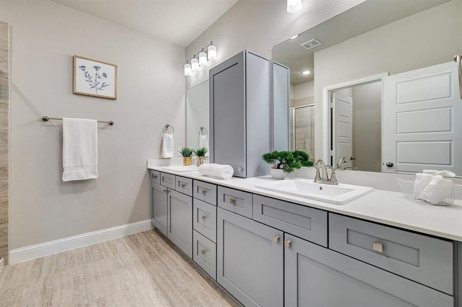 Bathroom featuring hardwood / wood-style flooring, vanity, and a shower with door