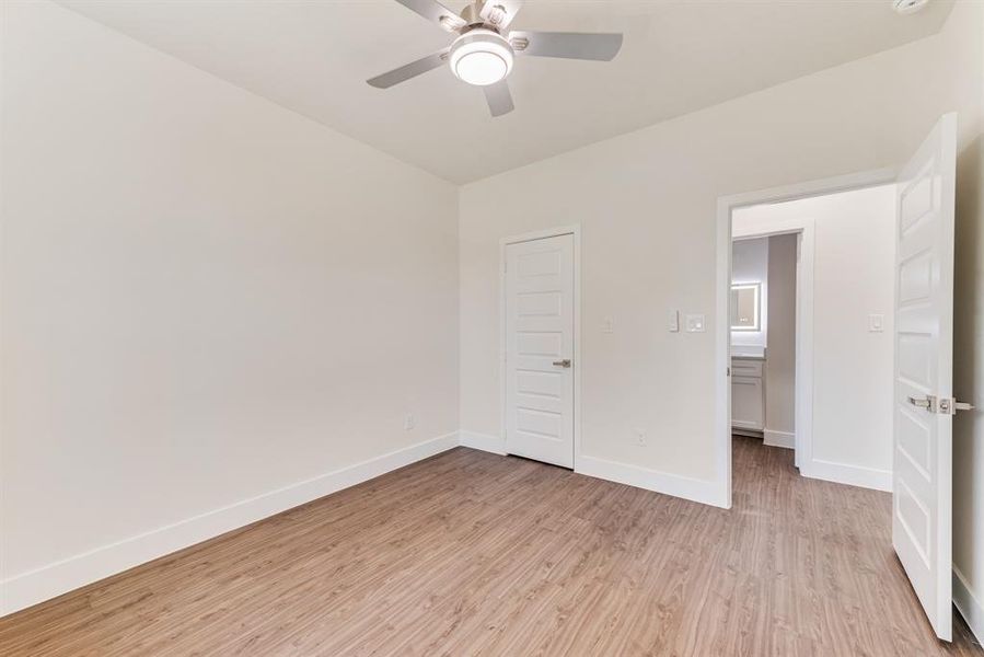 Unfurnished bedroom with light wood-type flooring, ceiling fan, and a closet