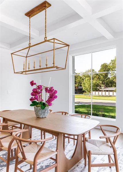 Dining area featuring beam ceiling, a chandelier, and coffered ceiling