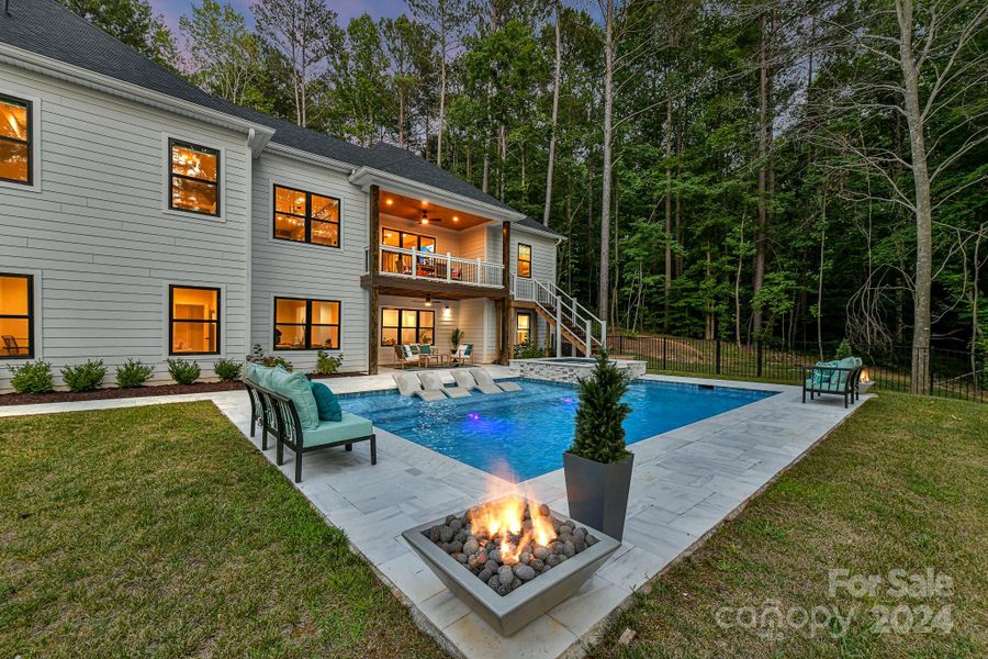 Outdoor Oasis features covered patio, spectacular, salt water pool/spa with sun bathing ledge & built in fire pits & plenty of pool decking for lounging!