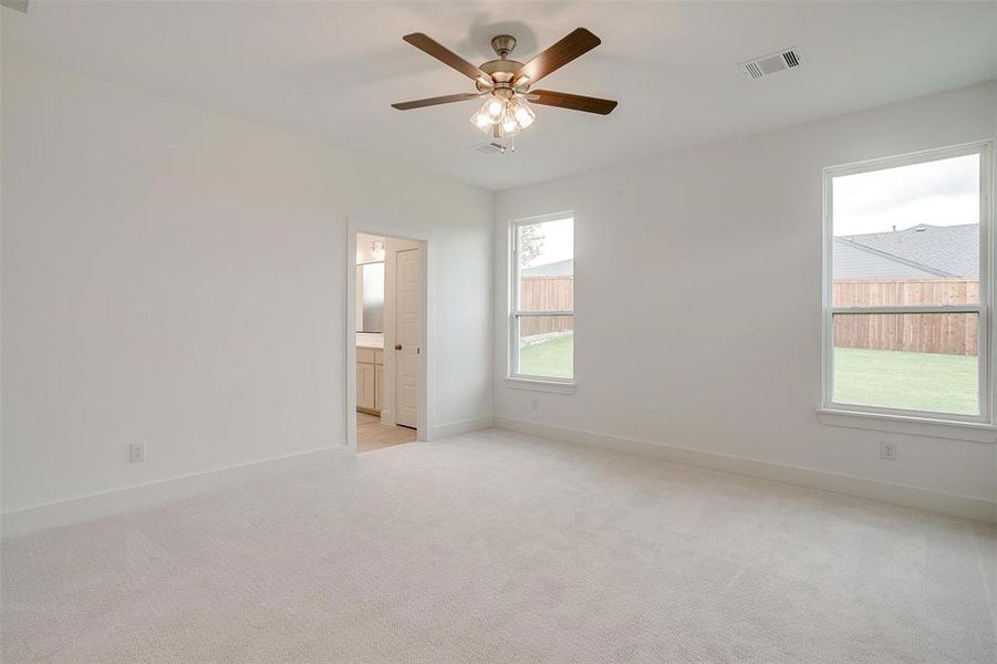 Carpeted empty room with ceiling fan