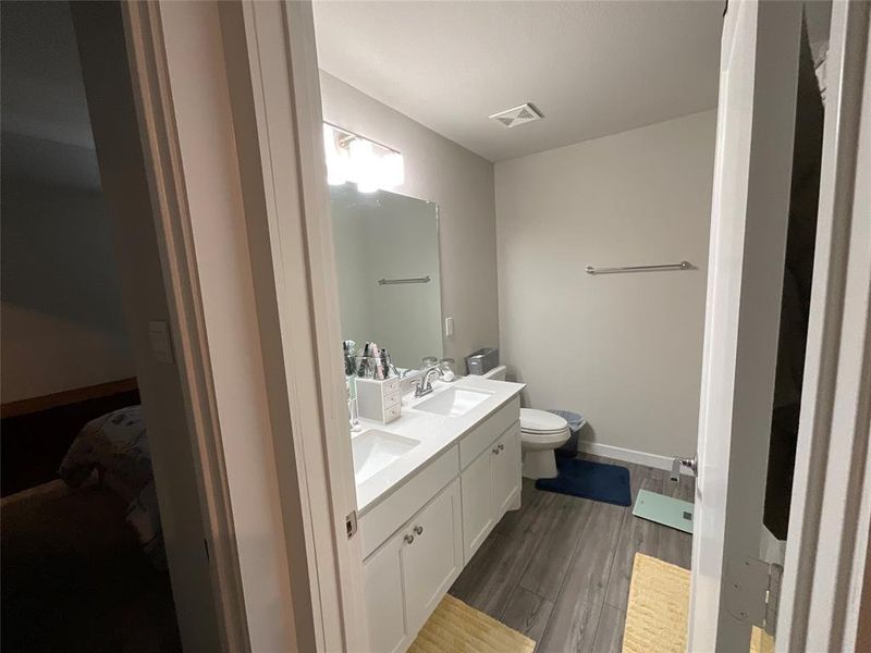 Bathroom featuring hardwood / wood-style floors, vanity, and toilet