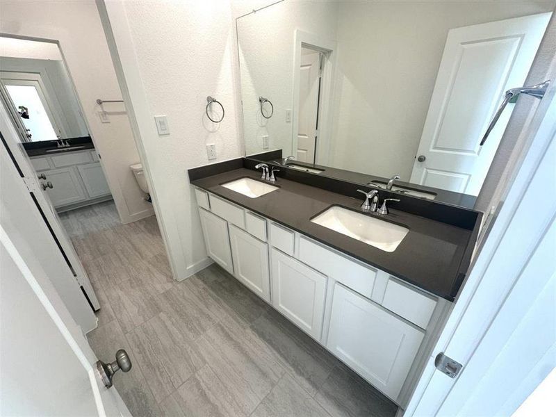 Guest bath is Hollywood style with access for all bedrooms and added sink, also with upgraded flooring and quartz countertops.