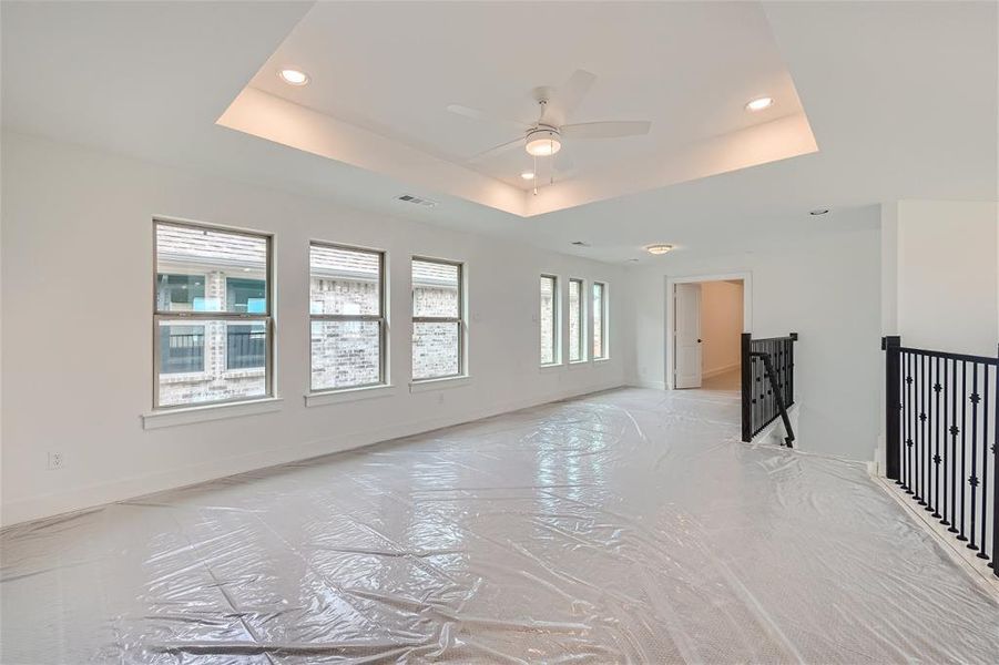 Game room with ceiling fan and a tray ceiling