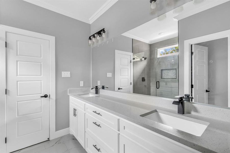 Bathroom with crown molding, a shower with door, and vanity