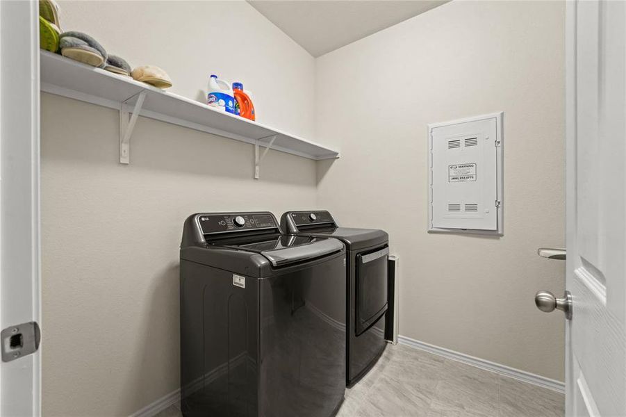 Laundry room featuring washer and dryer and light tile patterned floors