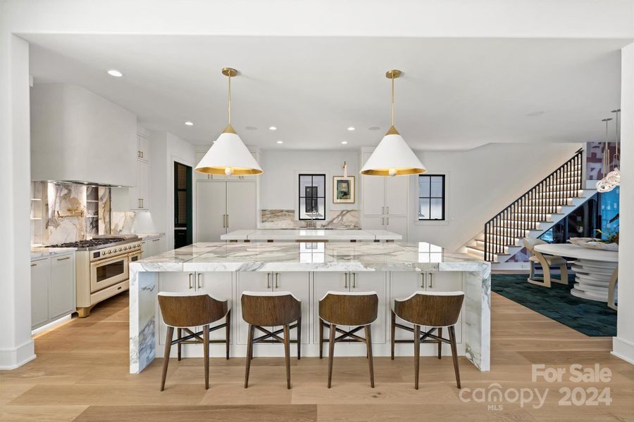 Kitchen with commercial appliances & custom cabinetry.