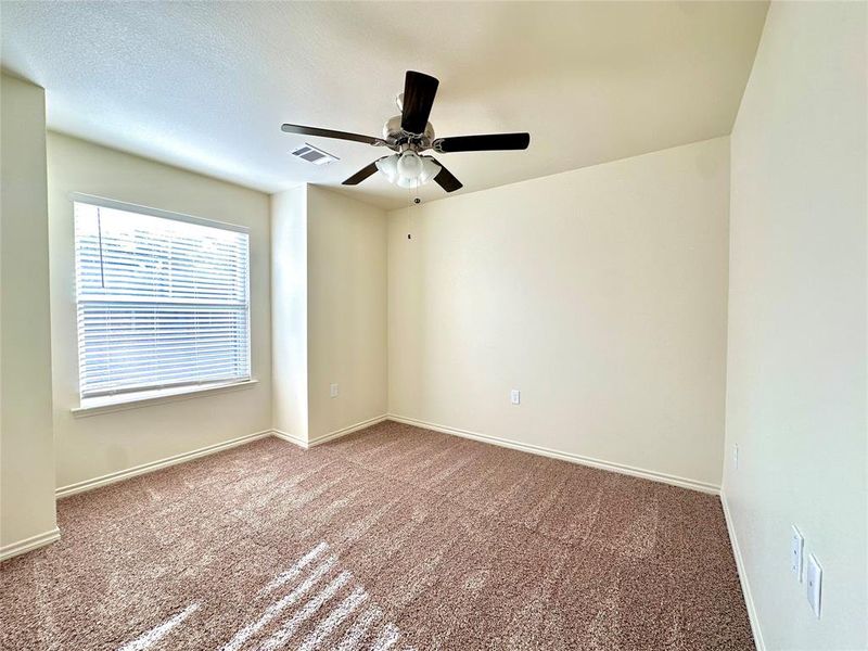 Carpeted empty room with ceiling fan