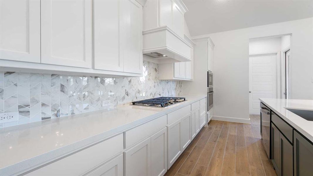 Kitchen featuring appliances with stainless steel finishes, light wood-type flooring, and white cabinetry