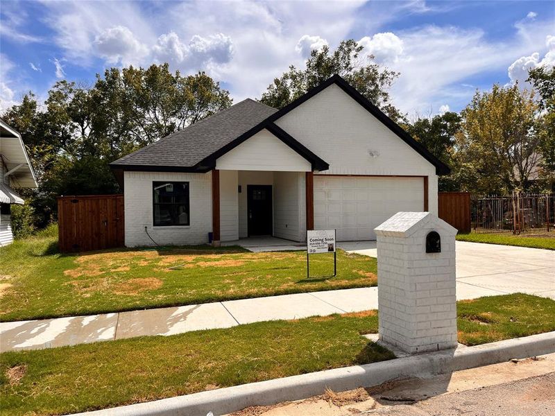 Ranch-style home featuring a front yard and a garage