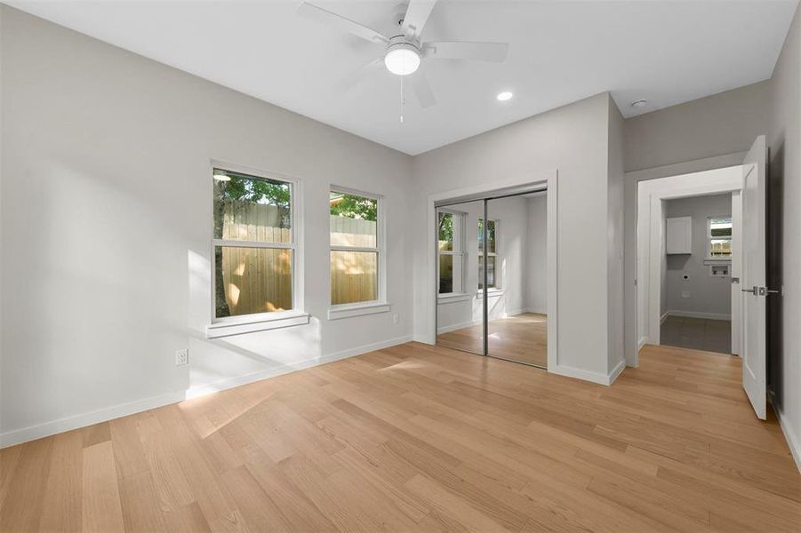 Unfurnished bedroom with a closet, light hardwood / wood-style flooring, and ceiling fan