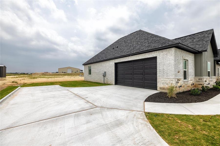 View of property exterior with a lawn and a garage