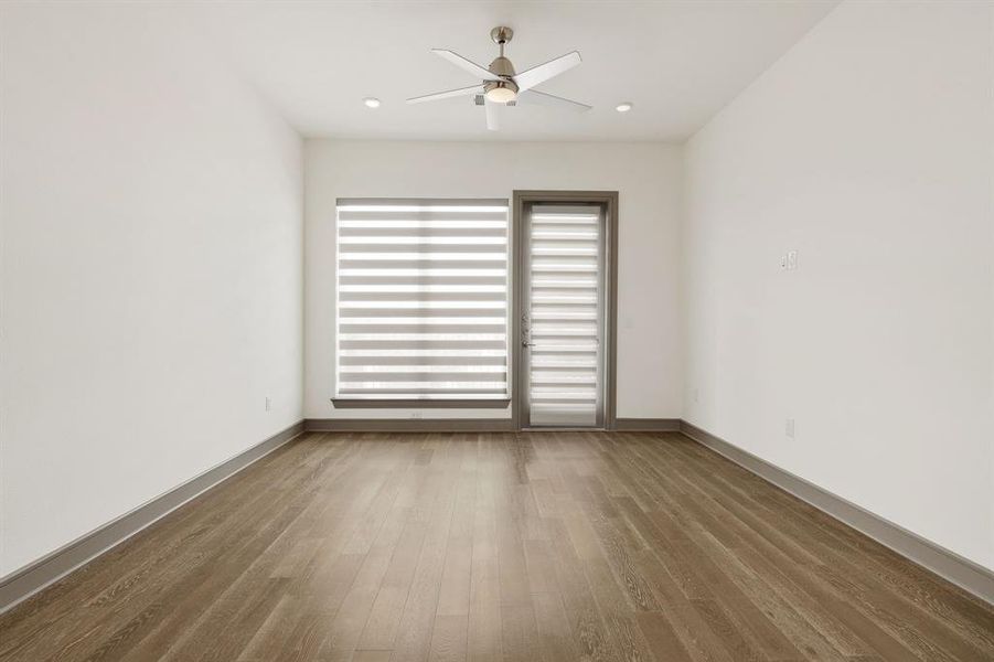 Spare room featuring plenty of natural light, ceiling fan, and wood-type flooring