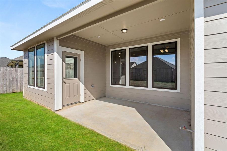 The covered patio is generously sized, providing ample space for various outdoor activities.