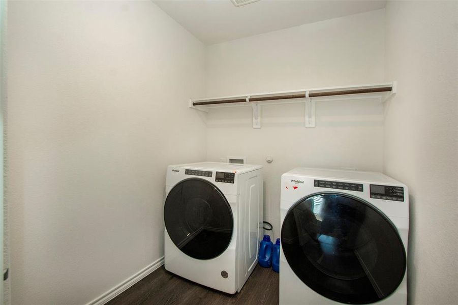 Laundry room with dark wood-type flooring and independent washer and dryer